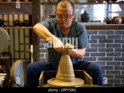 200615 -- NANCHANG, June 15, 2020 -- Craftsman Wu Yingshan makes a leaf cup at his studio in Ji an County, east China s Jiangxi Province, June 10, 2020. There are no two identical leaf cups, just as there are no two identical leaves in the world. The making of a leaf cup, a traditional craft endemic in today s Ji an County, is special -- the artisan has to integrate a leaf into the porcelain ware being worked on. Wu Yingshan, an inheritor of the leaf cup making techniques, started to study on porcelain in 2003. With the development of bulk production, the traditional ways to make leaf cups are Stock Photo