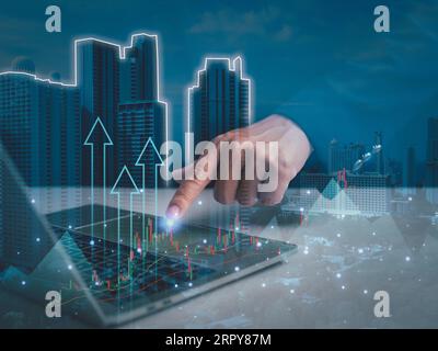 Stock trading. Finance. Investing. Growing business. Businessman in suit showing finger pointing to arrow tip on gray background. Stock Photo
