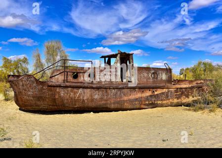 Rusting boat lying on the desert that used to be Aral Sea, the fourth largest lake in the world up until the 1960s. Muynak, Uzbekistan Stock Photo