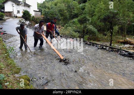 200709 -- HUANGSHAN, July 9, 2020 -- Villagers clean a flooded road in Zhangcun Village of Huizhou District in Huangshan City, east China s Anhui Province, July 9, 2020. Heavy rainfall hit the Huizhou District of Huangshan City, leaving several villages inundated in varying degrees. The local authorities rapidly organized flood response efforts to evacuate effected residents, rehabilitate destroyed roads and dredge silt-clogged ditches.  CHINA-ANHUI-HUANGSHAN-FLOOD-RESPONSE CN ZhouxMu PUBLICATIONxNOTxINxCHN Stock Photo