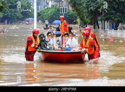 News Bilder des Tages China, Überschwemmungen in Region Guangxi 200711 -- RONGSHUI, July 11, 2020 -- Photo taken on July 11, 2020 shows rescuers transferring stranded people by boat in Rongshui, south China s Guangxi Zhuang Autonomous Region.  CHINA-GUANGXI-RONGSHUI-FLOOD-RESCUE CN HuangxXiaobang PUBLICATIONxNOTxINxCHN Stock Photo