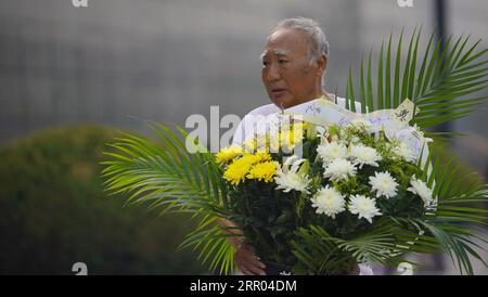 200728 -- TANGSHAN, July 28, 2020 -- A man holding a flower basket walks past a memorial wall in Tangshan, north China s Hebei Province, July 28, 2020, the 44th anniversary of the 1976 Tangshan Earthquake. Photo by /Xinhua CHINA-HEBEI-TANGSHAN-EARTHQUAKE-ANNIVERSARY CN DongxJun PUBLICATIONxNOTxINxCHN Stock Photo