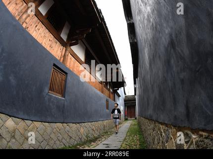 200802 -- FUZHOU, Aug. 2, 2020 -- A man visits Honglincuo in Xinhu Village, Bandong Township of Minqing County in southeast China s Fujian Province on July 17, 2020. Honglincuo is a well-preserved ancient dwelling compound in Xinhu Village of Fujian Province. The word cuo means dwelling place, house or small village in Fujian dialect. The family of Huang started to build the dwelling in 1795. Completed in 1823, the compound covers an area of about 17,832 square meters and has 35 halls, 666 rooms and 25 gardens. Designed and built as a whole structure, the spacious Honglincuo displays a high-le Stock Photo