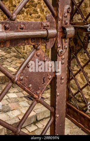Cast iron rusty old door metallic handle, Italy, selective shallow depth of field Stock Photo