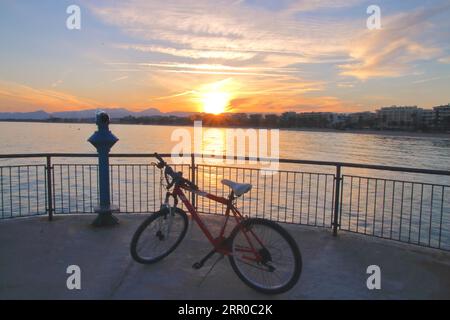 The picture was taken in Spain, on the edge of the marina in the town of Salou. In the photo seen a bicycle on the viewing platform. In the distance c Stock Photo