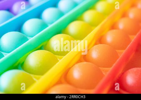 Close-up of the popular children's toy pop It fidget with soft focus. Macro. New popular silicone colorful pop It game. Anti-stress Stock Photo