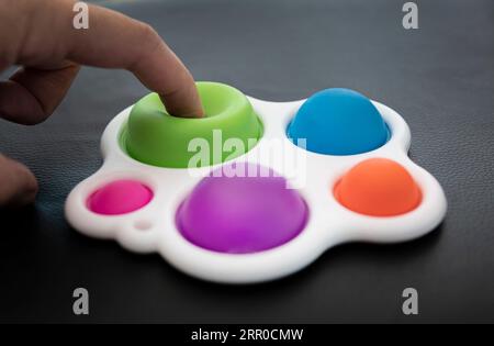 Close-up of the popular children's toy simple dimple fidget with soft focus. Macro. New popular silicone colorful pop It game. Anti-stress Stock Photo