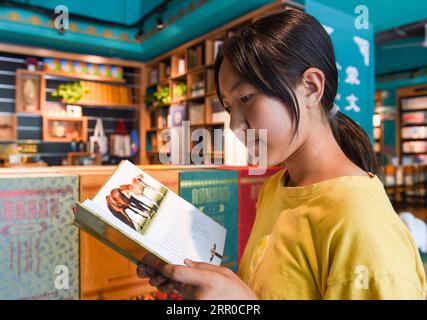 200809 -- XILIN GOL, Aug. 9, 2020 -- Xilinhua reads a book on equestrian culture in downtown Xilinhot, north China s Inner Mongolia Autonomous Region, Aug. 4, 2020. Summer vationtion has been Xilinhua s favorite time of year. In order to attend middle school, the 14-year-old lives most of the time with her grandparents in downtown Xilinhot, separated from her parents who run a ranch on the Baiyinxile pasture. Therefore, summer means both relaxation and reunion to the seventh grader. Xilinhua s father Gangsuhe is a famous horse rider. Learning from him, Xilinhua had also mastered equestrian ski Stock Photo