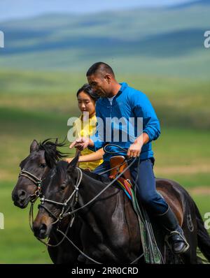200809 -- XILIN GOL, Aug. 9, 2020 -- Xilinhua L and his father Gangsuhe ride horses on the Baiyinxile grassland in Xilinhot, north China s Inner Mongolia Autonomous Region, Aug. 4, 2020. Summer vationtion has been Xilinhua s favorite time of year. In order to attend middle school, the 14-year-old lives most of the time with her grandparents in downtown Xilinhot, separated from her parents who run a ranch on the Baiyinxile pasture. Therefore, summer means both relaxation and reunion to the seventh grader. Xilinhua s father Gangsuhe is a famous horse rider. Learning from him, Xilinhua had also m Stock Photo