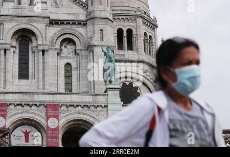 200811 -- PARIS, Aug. 11, 2020 -- A woman wearing a mask walks in front of the Basilica of the Sacred Heart Basilique du Sacre-Coeur at the Montmartre in Paris, France, Aug. 10, 2020. Cases of the novel coronavirus infection in France surpassed 200,000 on Monday, with 4,854 new infections confirmed over the last three days. The total of confirmed cases rose to 202,775 and 332 clusters are still active, according to the latest data released by the Health Ministry.  FRANCE-PARIS-COVID-19-CASES GaoxJing PUBLICATIONxNOTxINxCHN Stock Photo