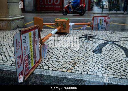 200819 -- MACAO, Aug. 19, 2020 Xinhua -- A motorcyclist rides past fallen signs of a bus stop in Macao, south China, Aug. 19, 2020. China s Macao Special Administrative Region has downgraded its typhoon signal from highest No.10 level to No.8 on Wednesday at 7:30 a.m. local time, but the low-lying areas near the coastline were flooded, as Typhoon Higos had made landfall in the neighboring city of Zhuhai in the morning. Macao Meteorological and Geophysical Bureau had upgraded its typhoon signal to No.10 level on Wednesday at 5:00 a.m. local time, before downgrading it to No.8 later on. The red Stock Photo