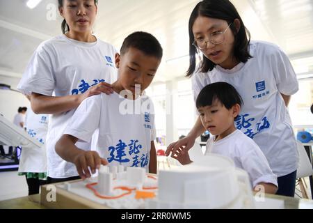 200827 -- LANZHOU, Aug. 27, 2020 -- Parents and children look at 3D printing models during a caring activity in Anning District of Lanzhou, northwest China s Gansu Province, Aug. 27, 2020. A caring activity for left-behind children in rural areas was held at a construction site of a women and children s hospital in Lanzhou on Thursday. Experts and volunteers conducted safety knowledge education to children and communicated with parents who are migrant workers here on family education and communication between parents and children.  CHINA-GANSU-LANZHOU-LEFT-BEHIND CHILDREN-SAFETY KNOWLEDGE EDUC Stock Photo