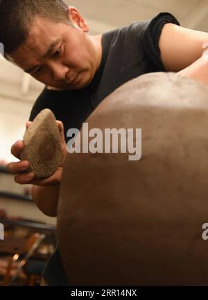 200904 -- HANGZHOU, Sept. 4, 2020 -- Yu Yuanfeng modifies a semi-finished pottery in his studio in Hangzhou, east China s Zhejiang Province, Sept. 3, 2020. Yu Yuanfeng, a master degree graduate in ceramic art of China Academy of Art, is fascinated by making coffee in different forms of pottery. He resigned from a university after working as a teacher for 11 years and set up a studio in the outskirts of Hangzhou to make various types of pottery to brew coffee.  CHINA-ZHEJIANG-COFFEE-POTTERYCN WengxXinyang PUBLICATIONxNOTxINxCHN Stock Photo