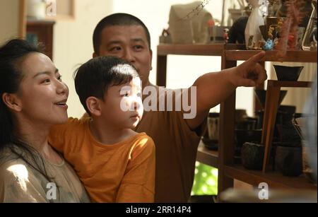 200904 -- HANGZHOU, Sept. 4, 2020 -- Yu YuanfengR shows his pottery works to visiting friends in his studio in Hangzhou, east China s Zhejiang Province, Sept. 1, 2020. Yu Yuanfeng, a master degree graduate in ceramic art of China Academy of Art, is fascinated by making coffee in different forms of pottery. He resigned from a university after working as a teacher for 11 years and set up a studio in the outskirts of Hangzhou to make various types of pottery to brew coffee.  CHINA-ZHEJIANG-COFFEE-POTTERYCN WengxXinyang PUBLICATIONxNOTxINxCHN Stock Photo