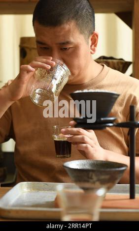 200904 -- HANGZHOU, Sept. 4, 2020 -- Yu YuanfengL smells the aroma in the glass after making coffee in his studio in Hangzhou, east China s Zhejiang Province, Sept. 1, 2020. Yu Yuanfeng, a master degree graduate in ceramic art of China Academy of Art, is fascinated by making coffee in different forms of pottery. He resigned from a university after working as a teacher for 11 years and set up a studio in the outskirts of Hangzhou to make various types of pottery to brew coffee.  CHINA-ZHEJIANG-COFFEE-POTTERYCN WengxXinyang PUBLICATIONxNOTxINxCHN Stock Photo