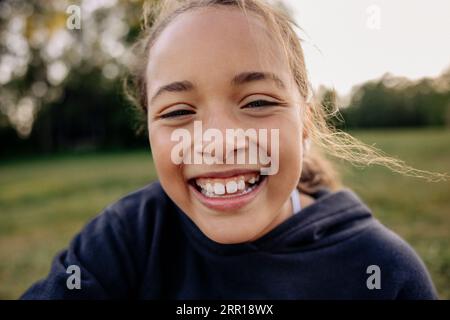 Portrait of happy girl laughing in playground Stock Photo