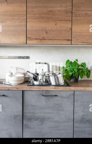 Dirty dishes and unwashed kitchen appliances filled the kitchen sink Stock Photo