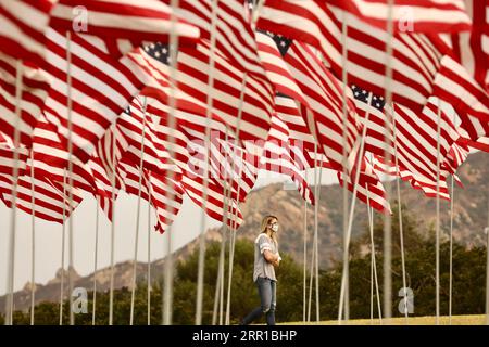 200911 -- LOS ANGELES, Sept. 11, 2020  -- A woman walks past the Waves of Flags display at Pepperdine University in Malibu, the United States, on Sept. 11, 2020. The Waves of Flags display commemorating the 19th anniversary of the 9/11 attacks was not open to the public this year due to the COVID-19 pandemic.  U.S.-MALIBU-9/11 ATTACKS-19TH ANNIVERSARY Xinhua PUBLICATIONxNOTxINxCHN Stock Photo