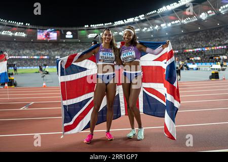 Amber Anning and Nicole Yeargin with her country's flag in the 4x400 meter relay at the World Athletics Championships in Budapest Stock Photo