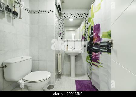 bathroom with white porcelain sink with matching pedestal, tile border and shower curtain Stock Photo
