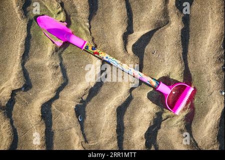 Broken and abandoned childs spade on beach Stock Photo