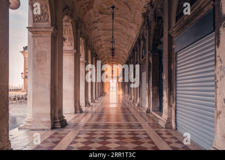 Magnificient view through arched passage with columns of old building of Library of Saint Mark on Saint Marks Square in Venice Stock Photo