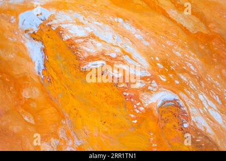 Top view of abstract background with bright yellow rough surface and blue colored granular micro mineral formations on marble stone in light Stock Photo
