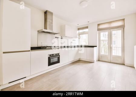 Interior of empty white kitchen with windows and wooden parquet floor Stock Photo