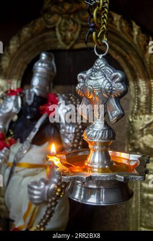 Oil lamp and statue in the Indian temple of Victoria, Mahé island, Seychelles Stock Photo