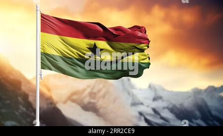 Flag of Ghana on a flagpole against a colorful sky Stock Photo