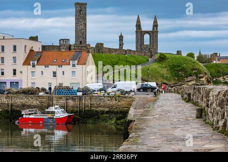 Small harbour with fishing boat and ruins of St Andrews Cathedral, St Andrews, Fife, Scotland, UK Stock Photo