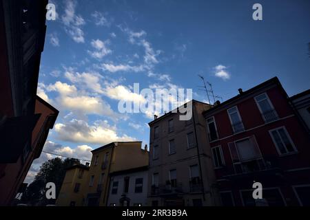 Sunset sky with clouds framed by the buildings of a street Stock Photo ...