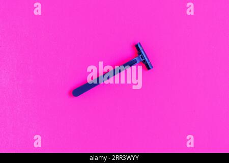 Non-permanent blue plastic shaving machine isolated on pink background Stock Photo