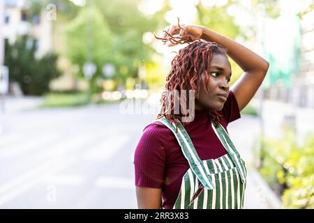 Thoughtful gender fluid person standing on city street Stock Photo