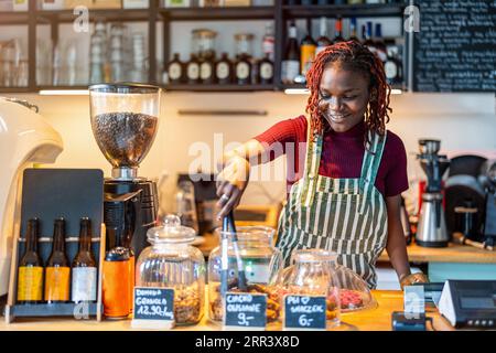 Portrait of a genderqueer barista making coffee at counter in coffee shop Stock Photo