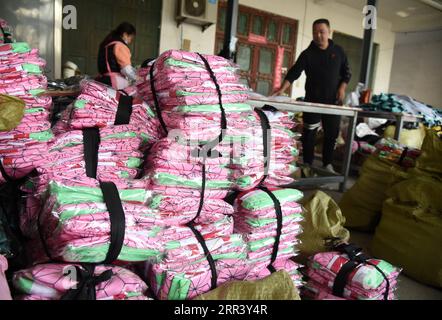 201114 -- HEZE, Nov. 14, 2020 -- Sun Kangjia 1st R, an online clothes store owner, packages costumes for sale to Japan at Sunzhuang Village of Caoxian County in Heze, east China s Shandong Province, Nov. 9, 2020. Sunzhuang Village thrives on e-commerce business. Among some 760 households in the village, more than 560 run online clothes stores on Taobao.com, Alibaba s main e-commerce site. The village s sales volume of costumes exceeded 200 million yuan about 30.22 million U.S. dollars in 2019.  CHINA-SHANDONG-HEZE-ONLINE BUSINESS CN WangxKai PUBLICATIONxNOTxINxCHN Stock Photo