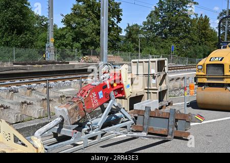 Red large construction machinery jack hammer and yellow tandem vibratory rollers. Stock Photo