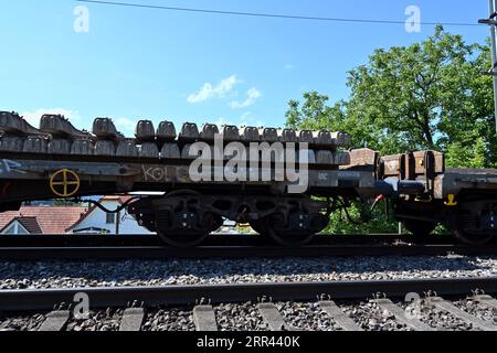 A railway carriage loaded with concrete sleepers stands on the rails leading to Urdorf station in Switzerland. Stock Photo