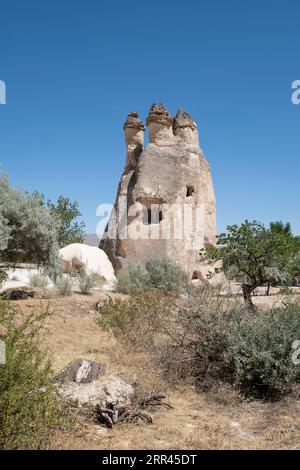 typical geological formation of weathered rock in the open air museum of Goreme, with housing dug into the rock, fairy chimney, at Cappadocia, Turkey Stock Photo