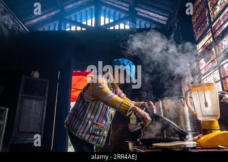 201127 -- KUNMING, Nov. 27, 2020 -- Dulong resident Dang Na makes pancakes in Kongdang Village of Dulongjiang Township, Gongshan Dulong and Nu Autonomous County, southwest China s Yunnan Province, Nov. 1, 2020. Dulong is a mountain-dwelling ethnic group in southwest China. It is one of the least populous of China s 56 minority nationalities. It is also called a direct-transition minority ethnic group because the Dulong people didn t bid farewell to primitive life until the founding of the People s Republic of China in 1949 and since then they directly stepped into the socialist society. Most D Stock Photo