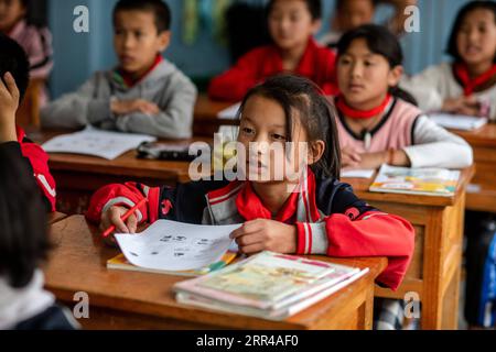 201127 -- KUNMING, Nov. 27, 2020 -- Dulong student Xiao Qinping attends a lesson at Dulongjiang Nine-Year Comprehensive School in Dulongjiang Township of Gongshan Dulong and Nu Autonomous County, southwest China s Yunnan Province, Oct. 31, 2020. Dulong is a mountain-dwelling ethnic group in southwest China. It is one of the least populous of China s 56 minority nationalities. It is also called a direct-transition minority ethnic group because the Dulong people didn t bid farewell to primitive life until the founding of the People s Republic of China in 1949 and since then they directly stepped Stock Photo