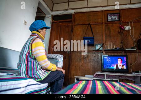 201127 -- KUNMING, Nov. 27, 2020 -- Dulong resident Dang Na watches TV at home in Dulongjiang Township of Gongshan Dulong and Nu Autonomous County, southwest China s Yunnan Province, Nov. 1, 2020. Dulong is a mountain-dwelling ethnic group in southwest China. It is one of the least populous of China s 56 minority nationalities. It is also called a direct-transition minority ethnic group because the Dulong people didn t bid farewell to primitive life until the founding of the People s Republic of China in 1949 and since then they directly stepped into the socialist society. Most Dulong people l Stock Photo