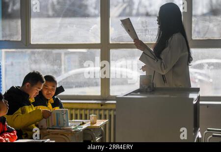 201202 -- CHIFENG, Dec. 2, 2020 -- Sun Simiao 1st, L and Wang Aoran 2nd, L are at class in the school in Chifeng City, north China s Inner Mongolia Autonomous Region, Nov. 25, 2020. Wang Aoran, 15, has been disabled in action by creatine kinase abnormality since he was a child. When in the second grade of primary school, he received help from schoolmate Sun Simiao, who voluntarily began to carry him from the school gate to his classroom. He has been helping him ever since. The two became inseparable best friends. They went to the same middle school, both in the same class, and they even became Stock Photo