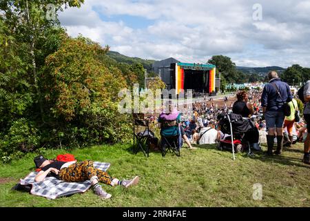 A woman takes a nap on a blanket overlooking the main Mountain Stage at Green Man Festival, Brecon, Wales, UK, 2023. Photo: Rob  Watkins Stock Photo