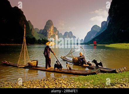 Li River, Guangxi, China: Cormorant fishermen on their bamboo rafts at rest along river near Xingping (Guilin area). Stock Photo