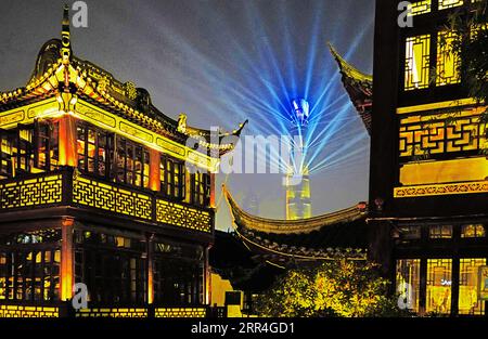 Light show on Shanghai Tower in Pudong seen from Old City's Huxinting Tea House in Shanghai. Stock Photo