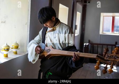 201206 -- CHENGDU, Dec. 6, 2020 -- Tamdrin tries to play the Zhamunie, a traditional Tibetan musical instrument, at the Sounds of Himalaya Museum in Letong Town of Litang County, the Tibetan Autonomous Prefecture of Garze, southwest China s Sichuan Province, Dec. 2, 2020. Tamdrin, whose Mandarin name is Ding Zhen, is a 20-year-old Tibetan herder from a village of Litang County in the Tibetan Autonomous Prefecture of Garze in Sichuan Province. Less than a month ago, he was still an ordinary herder, until a 7-second video featuring a smiling Tamdrin went viral, making him the latest social media Stock Photo