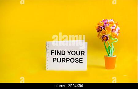 Notepad on a yellow background with the inscription FIND YOUR PURPOSE. Stock Photo
