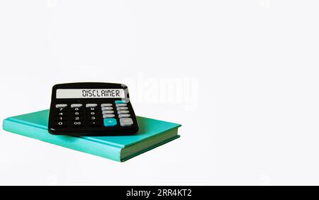Disclaimer on the display of a calculator, which lies on a notepad and a white background. Stock Photo