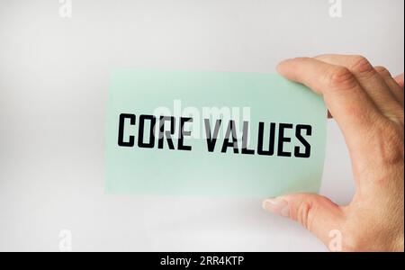 Text Core Values on a colored sticker in a mans hand, copy space Stock Photo